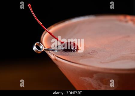 Gros plan d'un martini au chocolat versé dans un verre réfrigéré avec un fond de humeur changeante. Banque D'Images