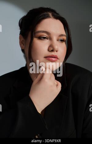 Élégante femme de taille plus pose soigneusement, incarnant la mode et l'assurance de soi dans sa tenue. Banque D'Images