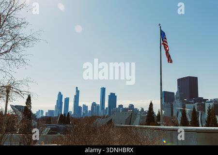 Par temps clair, on voit les gratte-ciel de Chicago avec de hauts bâtiments et un drapeau américain agitant au premier plan. La scène capture la vie urbaine et architectural Banque D'Images