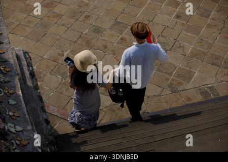 Couple de touristes avec chapeaux à larges bords explorant au temple thaïlandais, vue en angle élevé Banque D'Images