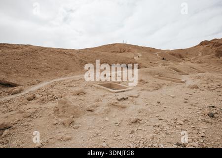 Vue sur le paysage désertique accidenté de la Vallée des Reines (Ta-Set-Neferu) sur la Cisjordanie du Nil, avec des entrées de tombes rectangulaires. Banque D'Images