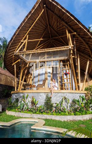 Jeune femme appréciant le petit déjeuner à la Villa tropicale de luxe avec piscine privée à Bali Banque D'Images