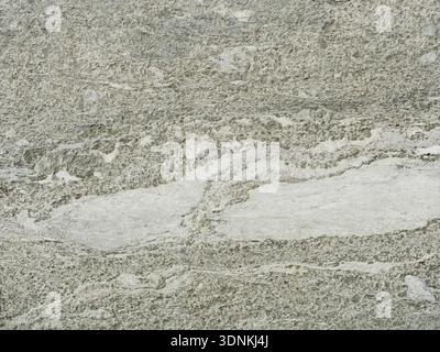 Surface en pierre de type granit dans des tons gris avec texture rugueuse et inclusions plus légères. Gros plan. Copyspace. Banque D'Images