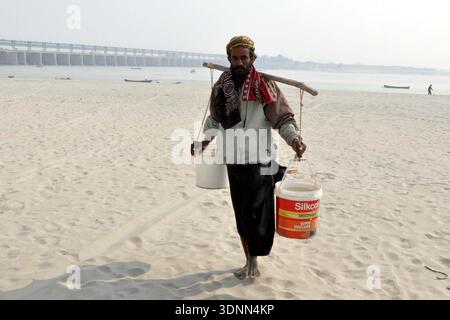 Un homme de passage après avoir rempli des bidons d’eau de la rivière Indus en raison d’une pénurie d’eau potable dans leur région, à Hyderabad le mercredi 11 février 2026. Banque D'Images