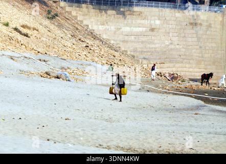 Un homme de passage après avoir rempli des bidons d’eau de la rivière Indus en raison d’une pénurie d’eau potable dans leur région, à Hyderabad le mercredi 11 février 2026. Banque D'Images