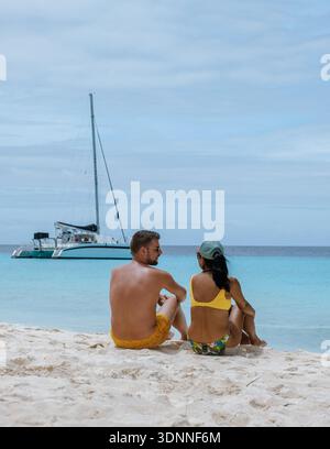 Une scène de plage sereine à Klein Curaçao met en scène un couple assis ensemble, appréciant les uns les autres compagnie. Le sable doux et les eaux turquoises limpides créent un cadre parfait pour la détente et le romantisme. Banque D'Images