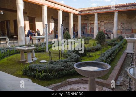 Maison des Vettii, Casa dei Vettii, à Pompéi. Jardin péristyle romain montrant des haies restaurées, des fontaines et des fresques sur les murs environnants, il Banque D'Images
