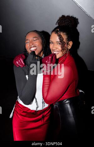 Deux femmes capturées dans un portrait flash, exsudant le bonheur et la chaleur alors qu'elles profitent d'une nuit vibrante ensemble. Leurs expressions joyeuses mettent en valeur th Banque D'Images