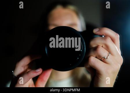 Gros plan d'une personne tenant un appareil photo et prenant une photo Banque D'Images