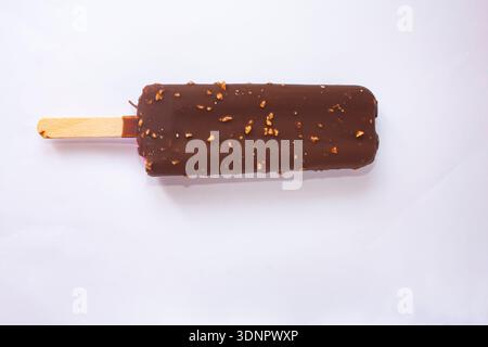 Crème glacée au chocolat avec des noix sur un bâton Banque D'Images