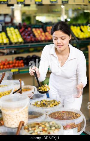 Une jeune femme a cueillir des olives au supermarché Banque D'Images