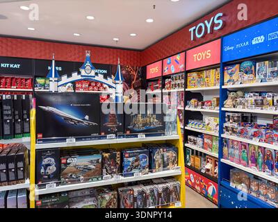 Toys and games merchandise display in an airport duty free store. Featuring LEGO sets (Concorde, Star Wars, Harry Potter), Disney, and Pixar character Banque D'Images