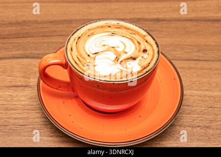 La danse intime du lait et de l'espresso, où l'épaisse crème tourbillonne et tourbillonne avec le blanc à la surface d'une tasse en céramique rustique Banque D'Images