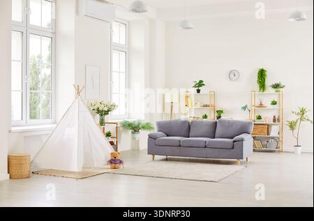 Un intérieur confortable de salon moderne avec un canapé gris et une tente de tipi pour enfants Banque D'Images