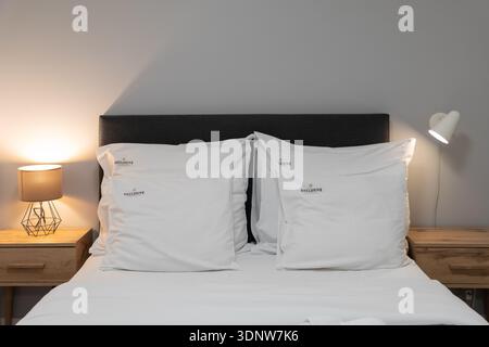 Cracovie, Pologne - 30 novembre 2025 : chambre bien aménagée présentant un lit confortable avec des draps blancs frais, tables de nuit en bois et ambiance chaleureuse Banque D'Images