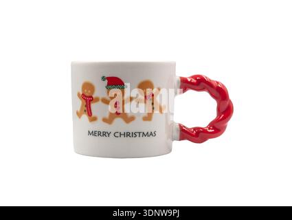 Un mug festif avec les mots Joyeux Noël et un imprimé pain d'épices avec une poignée torsadée rouge sur fond blanc Banque D'Images
