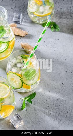 Boisson rafraîchissante avec citron, concombre et menthe servie dans des verres sur une surface texturée Banque D'Images