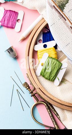 Fils de broderie colorés et outils disposés dans un espace de travail créatif avec espace de copie Banque D'Images
