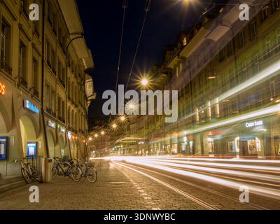 Tram passant par la rue commerçante Kramgasse à Berne la nuit Banque D'Images