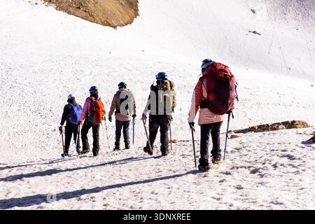 Un groupe de randonneurs, équipés de sacs à dos et de bâtons, traverse les pentes enneigées d'Iztaccihuatl, au Mexique. La scène capture l'esprit aventureux de Banque D'Images