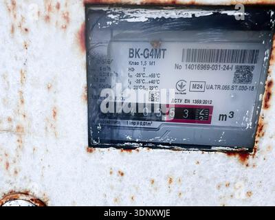 Lviv, Ukraine - 07 février 2026 : compteur de gaz rouillé avec étiquette usée et surface métallique altérée dans un environnement industriel. Banque D'Images