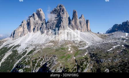 Vue aérienne captivante de la majestueuse Tre Cime di Lavaredo dans les Dolomites, en Italie, sous un ciel bleu immaculé, présentant des sommets escarpés et des contrastes Banque D'Images