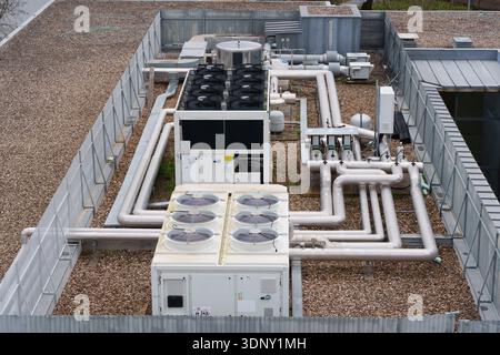 Système HVAC industriel de toit avec unités de climatisation et un réseau complexe de tuyaux isolés sur une surface de gravier Banque D'Images