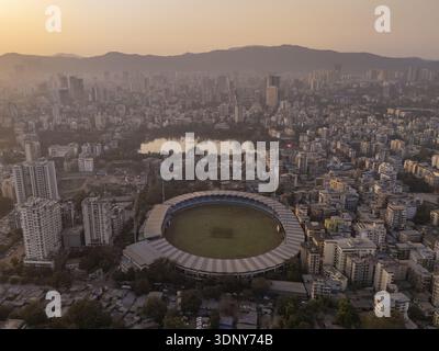 Vue aérienne du stade niché au milieu du paysage urbain tentaculaire, avec le lac tranquille reflétant la lumière douce, Thane, Maharashtra, Inde. Banque D'Images