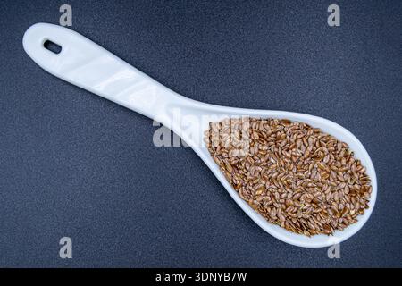 Beaucoup de délicieuses graines de lin d'été sur le comptoir du marché de l'épicerie, nourriture biologique savoureuse composée de graines de lin crues fraîches de près, belle texture mûre de Banque D'Images
