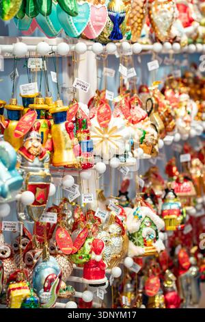Gros plan d'ornements en verre colorés fabriqués à la main suspendus à la vente dans un cadre de marché ou de magasin Banque D'Images