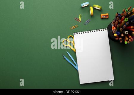 Concept de retour à l'école. Fournitures scolaires fixes colorées sur fond vert, espace ou texte à plat Banque D'Images