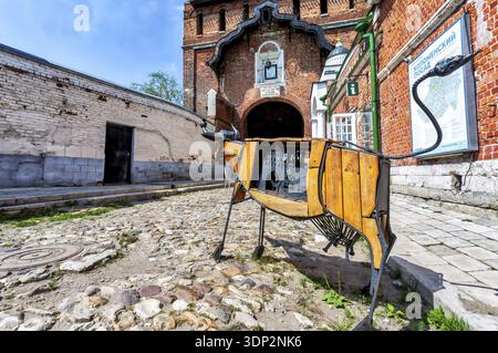 Kolomna, Russie - 7 juillet 2020 : installation artistique sous forme de vache en bois à côté de la porte Pyatnitski du Kremlin de Kolomna Banque D'Images