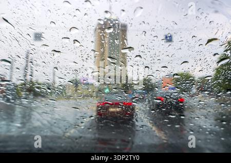 Gouttes de pluie sur un pare-brise de voiture. Voiture de conduite sous la pluie avec des gouttes de pluie sur le pare-brise, embouteillage dans les jours de pluie Banque D'Images
