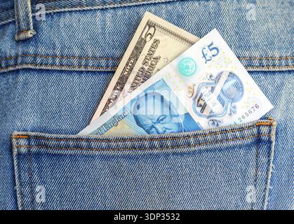 Billet de banque britannique de cinq livres sterling et cinq dollars américains sortant de la poche arrière du Jean pour voyager et faire du shopping Banque D'Images
