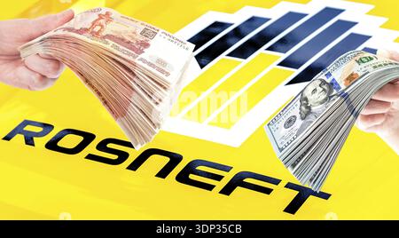 Samara, Russie - 27 mai 2023 : Rosneft Oil Company logo, pile de roubles russes et dollars américains dans les mains. Rosneft est l'un des plus grands russ Banque D'Images