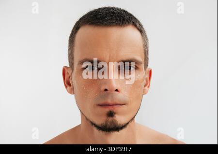 Visage masculin avec cache-yeux hydratants. Routine de soin de la peau Banque D'Images