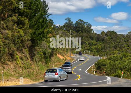 Voitures sur une route de montagne typiquement sinueuse sur la péninsule de Coromandel, Nouvelle-Zélande Banque D'Images