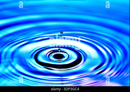 une goutte d'eau tombant dans l'eau et créant des vagues Banque D'Images