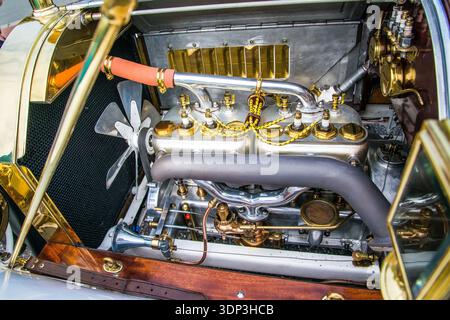 Vue d'un moteur de voiture vintage hautement poli avec deux blocs argentés avec des chapeaux en laiton et un câblage jaune complexe Banque D'Images
