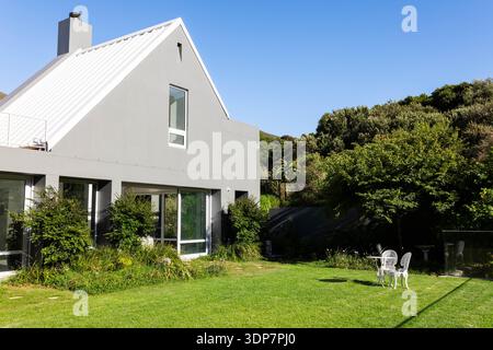 Maison grise moderne de deux étages est assis à gauche du cadre sur la pelouse bien entretenue avec un ensemble de bistrot blanc Banque D'Images