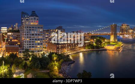 Front de mer de Brooklyn DUMBO au crépuscule avec pont de Brooklyn, Empire Fulton Ferry Park, Jane’s Carousel et paysage urbain illuminé. New York Banque D'Images