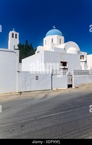 Une église orthodoxe grecque blanche traditionnelle avec un dôme bleu et un clocher sous un ciel clair, caractéristique de l'architecture étonnante sur l'île grecque Banque D'Images
