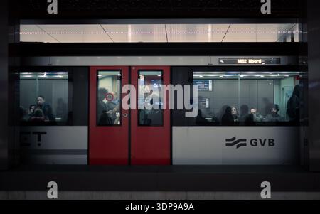 Amsterdam, pays-Bas - 17 janvier 2025 : train de métro avec portes rouges dans une gare. Passagers visibles à travers les fenêtres. Logo GVB. Transpor public urbain Banque D'Images