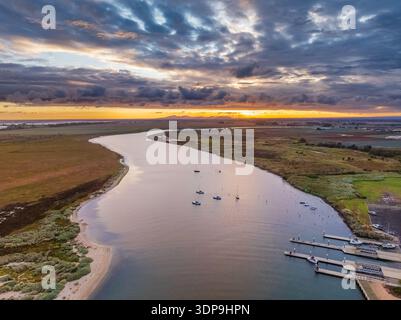 Vue aérienne de l'embouchure d'une rivière côtière avec des bateaux sous un ciel de coucher de soleil coloré à Werribee South dans Victoria, Australie. Banque D'Images