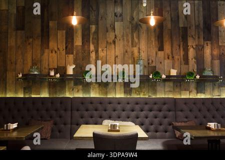 Intérieur en bois confortable d'un restaurant moderne avec sièges confortables et éclairage d'ambiance Banque D'Images