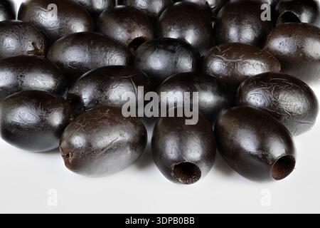 Motif macro d'olives noires formant un cluster répétitif, fond à contraste élevé, surfaces brillantes studiolit, composition abstraite pour l'emballage ou backgro Banque D'Images