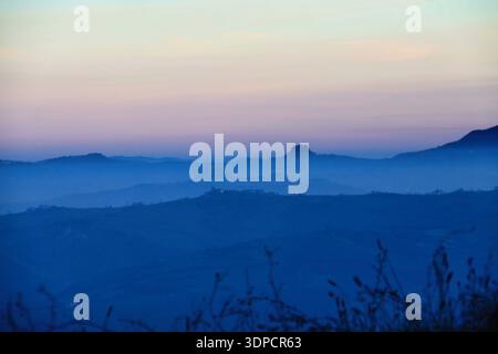 Heure bleue sur les collines ondoyantes et les châteaux antiques à la tombée du jour. Un paysage large et cinématographique des collines de Reggio Emilia en Italie pendant l'heure bleue. Banque D'Images
