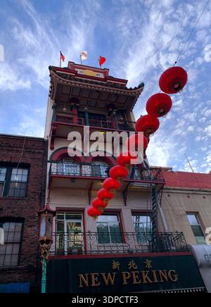 Architecture chinoise traditionnelle avec un bâtiment de plusieurs étages orné de lanternes rouges et d'éléments décoratifs dans un cadre urbain dynamique Banque D'Images
