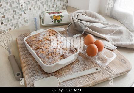 Gâteau éponge avec pétales, flocons d'amande et sucre en poudre. Dessert et fête à la maison. Cuisine et passe-temps. Banque D'Images