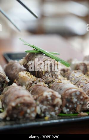 Gros plan de Sundae de saucisse de sang coréenne tranchée garnie de graines de sésame et d'oignons verts Banque D'Images
